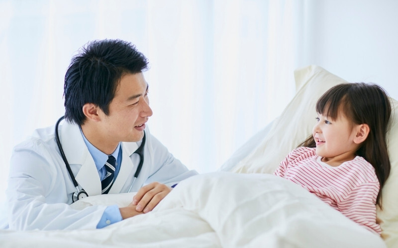 マレーシアの病院で医師が子どもの患者に声をかけている様子