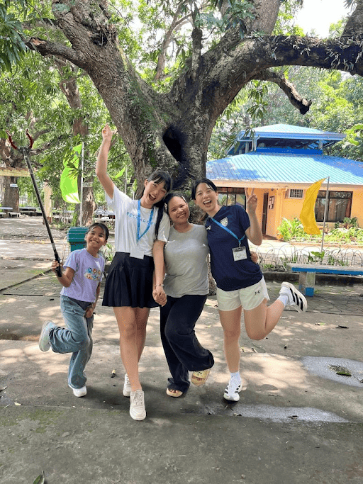 Maho, Reeracoen Malaysia Career Advisor, posing joyfully outdoors with a group outdoors during a community event.