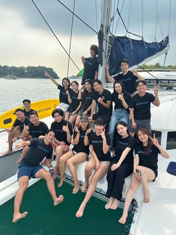 Maho, Reeracoen Malaysia Career Advisor, posing with colleagues on a sailboat deck during a company trip
