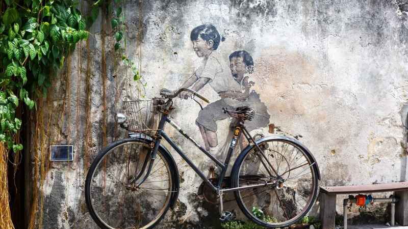 Steert Art mural boy and girl on bicycle on a wall in Georgetown, Penang Island